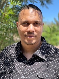  Freelance Software Developer male sitting on top of a couch in a Las Vegas hotel room, coding on his laptop 
                            with a large window in the background over looking the Las Vegas stip.